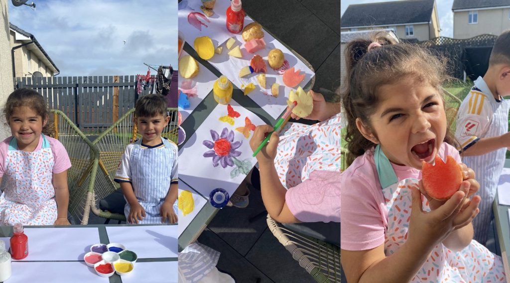 A girl and a boy preparing their #TattieArtChallenge entries out in their garden, painting with potatoes.